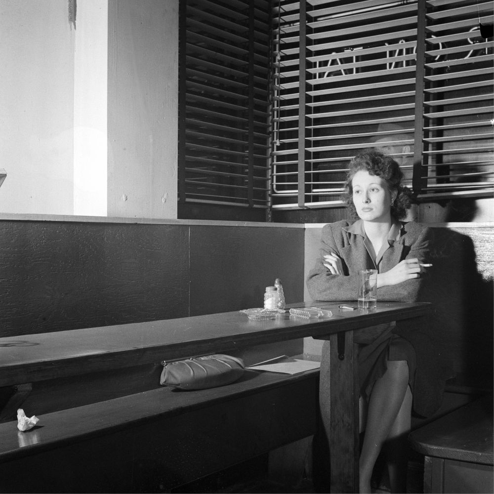Monochrome photo showing girl alone in bar